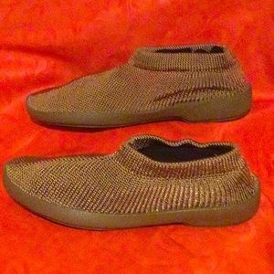 Soft tan/copper colored knitted shoes with plastic hard soles, size large.